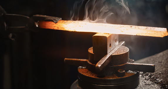 Rod hot iron on the anvil ready to be beaten.