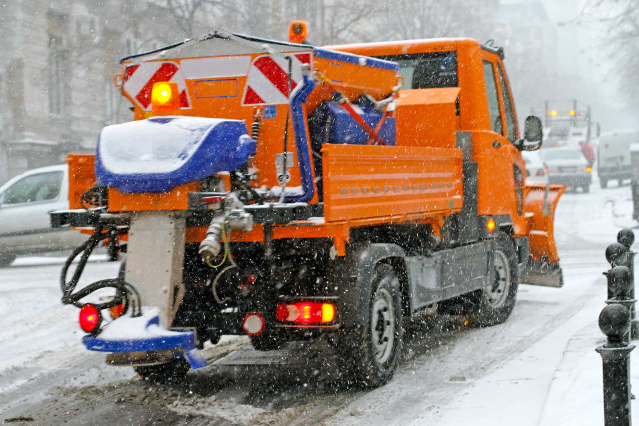 Spreader Truck in Winter Snow Blizzard Weather
